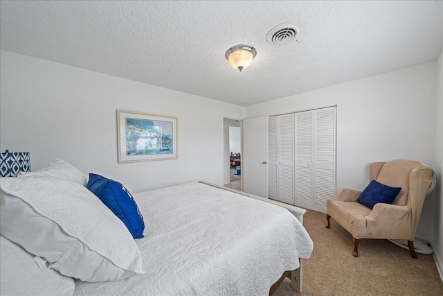 carpeted bedroom with a textured ceiling and a closet