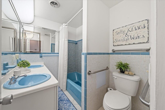 full bathroom featuring tile walls, vanity, toilet, tile patterned floors, and shower / bath combo with shower curtain