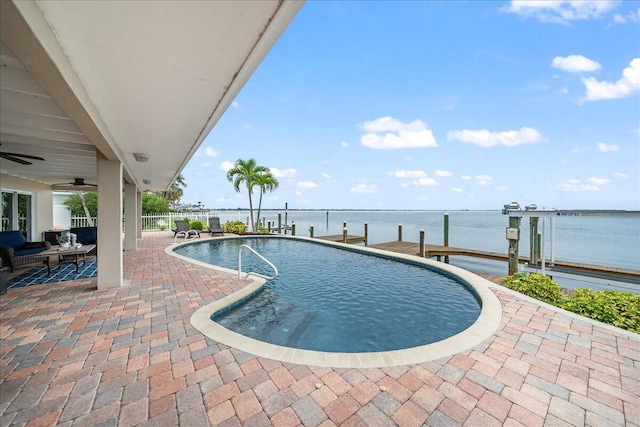 view of swimming pool with a water view, ceiling fan, and a patio area