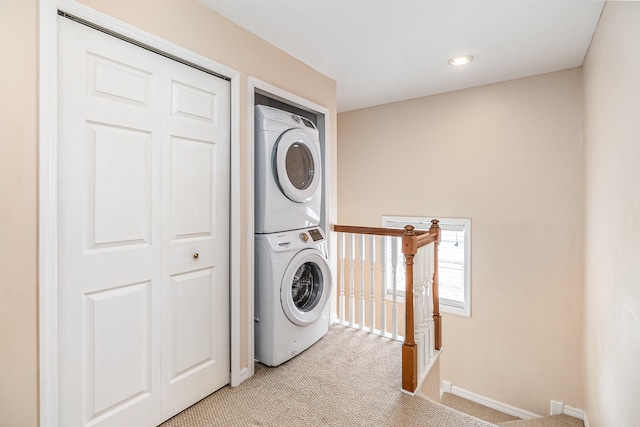 laundry room with stacked washer and dryer and light carpet