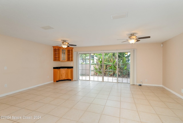 unfurnished living room with ceiling fan and light tile patterned floors