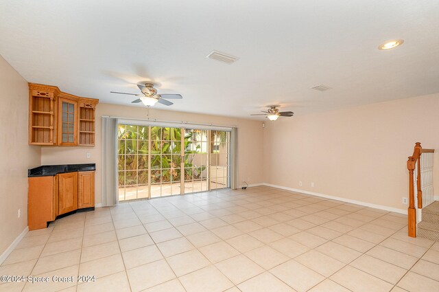 empty room with ceiling fan and light tile patterned flooring