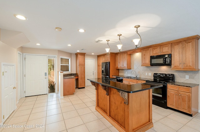 kitchen featuring sink, black appliances, a kitchen breakfast bar, pendant lighting, and a kitchen island