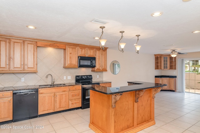 kitchen featuring a kitchen island, sink, black appliances, a breakfast bar area, and ceiling fan