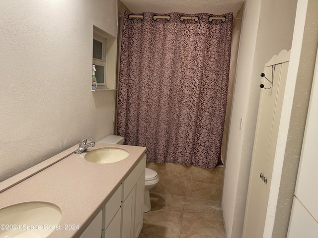 bathroom with tile patterned flooring, vanity, and toilet