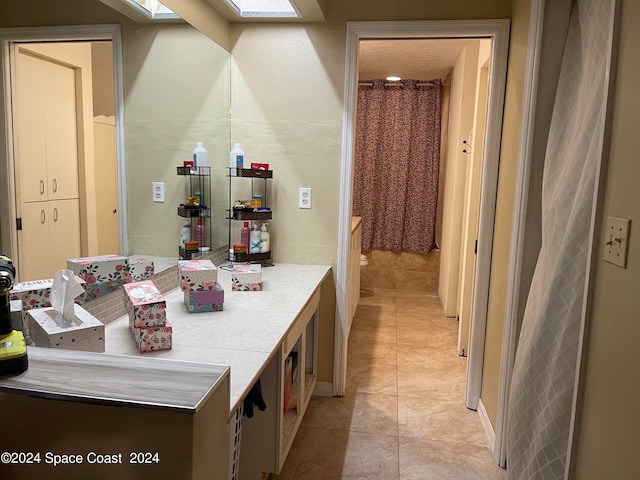 bathroom with tile patterned flooring and a skylight