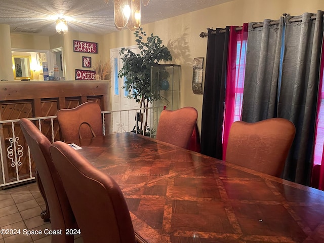 tiled dining area with a textured ceiling