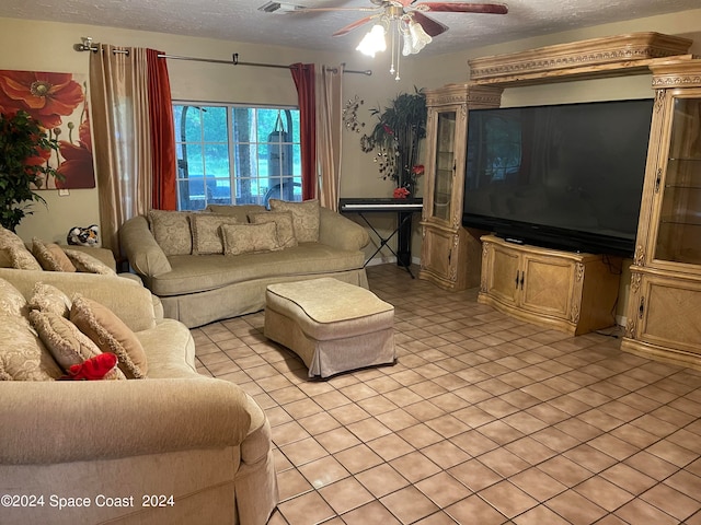 living room with ceiling fan, light tile patterned floors, and a textured ceiling