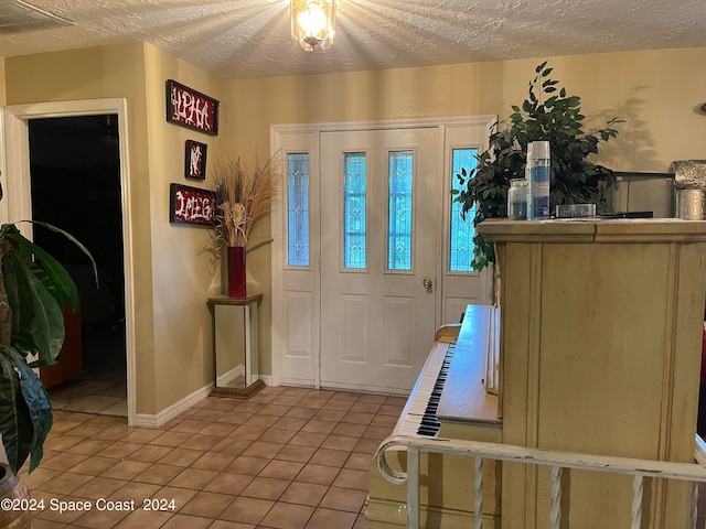 entryway featuring light tile patterned flooring and a textured ceiling