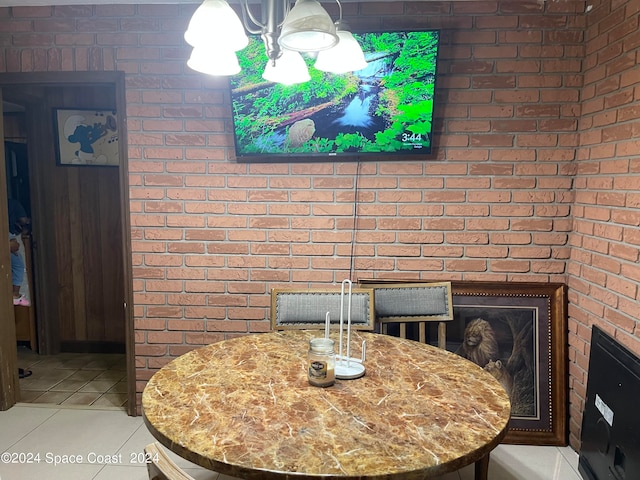 tiled dining space featuring brick wall