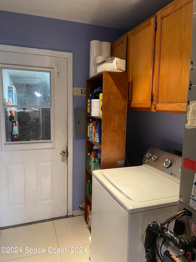 laundry room featuring washer / clothes dryer, light tile patterned floors, and cabinets