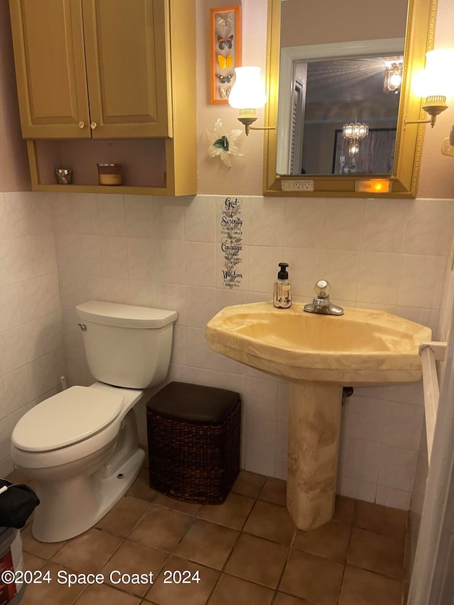 bathroom featuring tile patterned floors, toilet, and tile walls