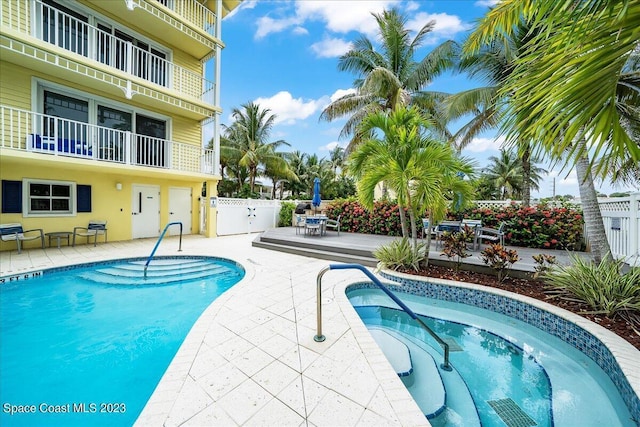 view of pool featuring a patio area and an in ground hot tub