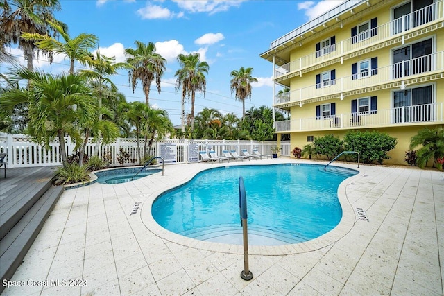 view of swimming pool with a patio and a community hot tub