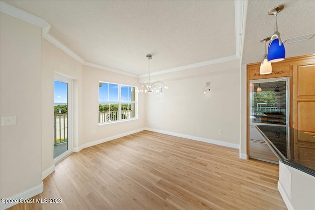 unfurnished dining area featuring a textured ceiling, light hardwood / wood-style flooring, ornamental molding, and a chandelier