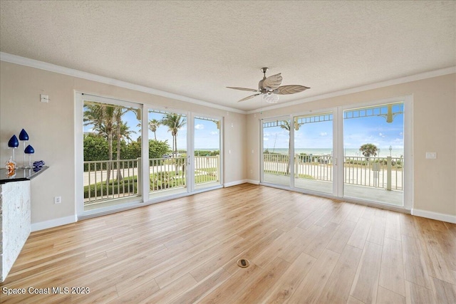 unfurnished sunroom featuring ceiling fan, a healthy amount of sunlight, and a water view