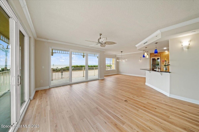 unfurnished living room with ceiling fan with notable chandelier, a textured ceiling, light hardwood / wood-style flooring, and ornamental molding