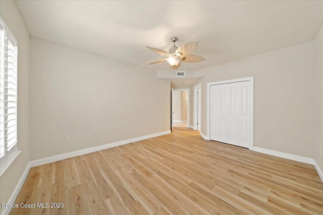 spare room featuring ceiling fan, plenty of natural light, a textured ceiling, and light hardwood / wood-style floors