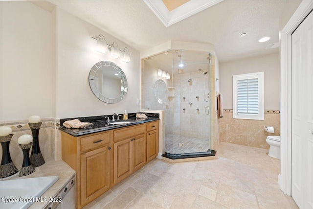 bathroom featuring toilet, tile walls, walk in shower, a textured ceiling, and vanity