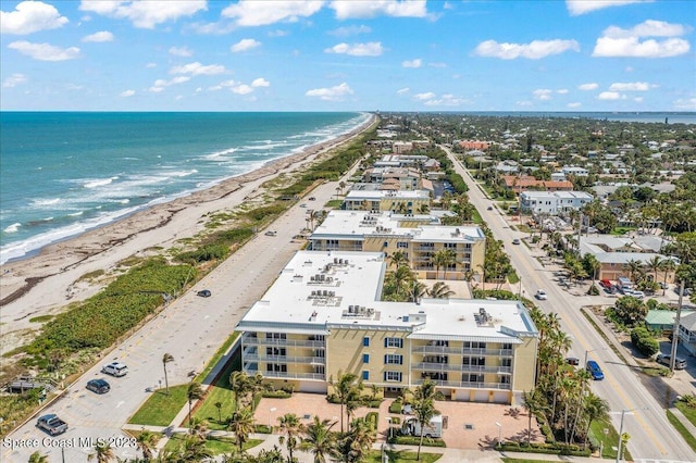 drone / aerial view featuring a water view and a view of the beach