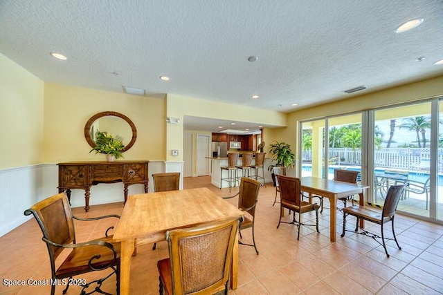 tiled dining space with a textured ceiling