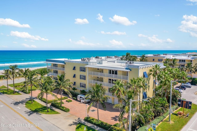 drone / aerial view with a water view and a beach view