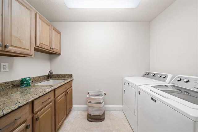 laundry room with washer and clothes dryer, sink, a textured ceiling, and cabinets