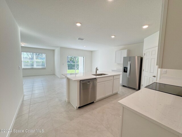 kitchen featuring sink, an island with sink, white cabinets, and appliances with stainless steel finishes