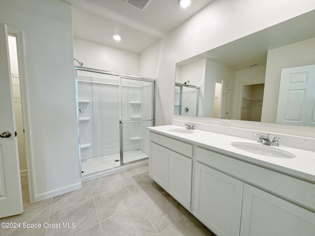 bathroom with vanity, tile patterned flooring, and a shower with door