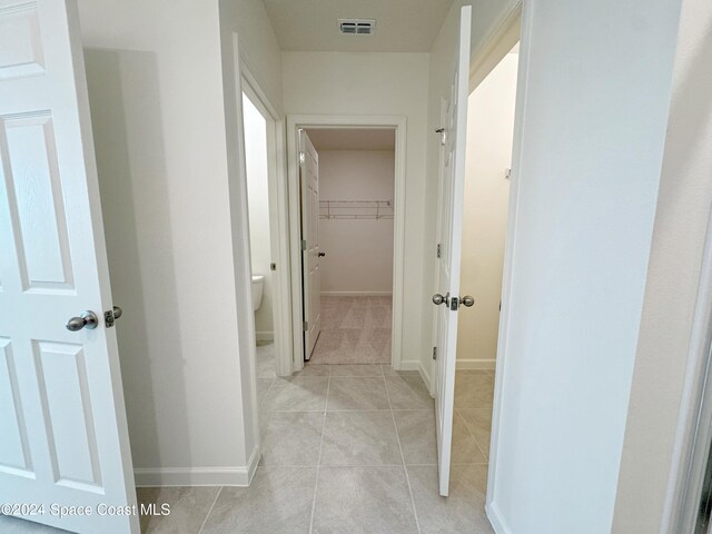 hall featuring light tile patterned flooring