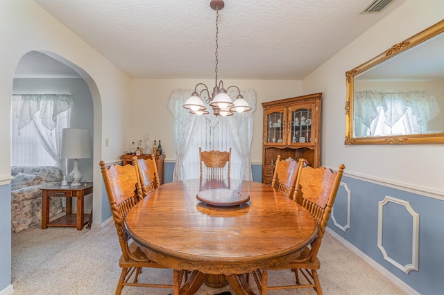 dining area featuring an inviting chandelier and a textured ceiling