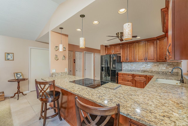 kitchen with vaulted ceiling, tasteful backsplash, black appliances, sink, and kitchen peninsula