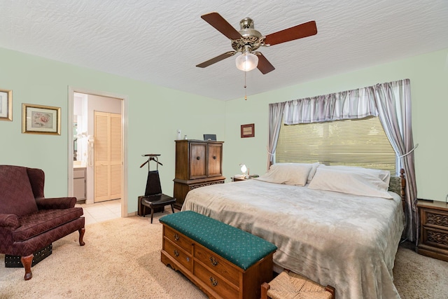 carpeted bedroom with connected bathroom, a textured ceiling, and ceiling fan