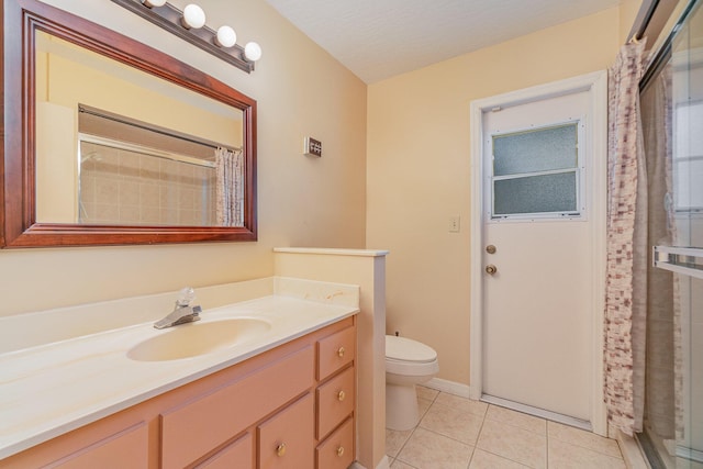 bathroom featuring curtained shower, vanity, toilet, tile patterned floors, and a textured ceiling