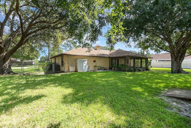 back of property featuring a yard