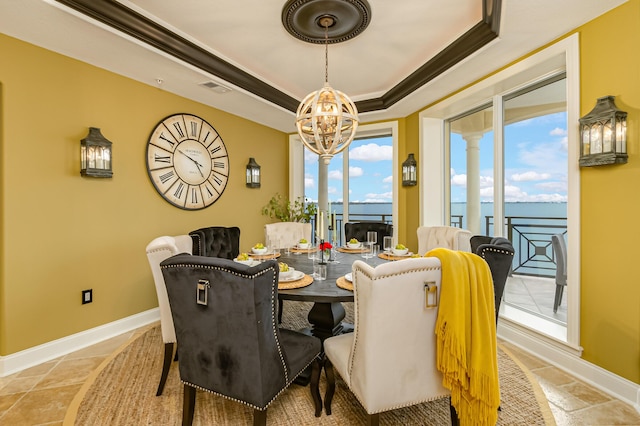 dining room with crown molding, a wealth of natural light, a raised ceiling, and a chandelier