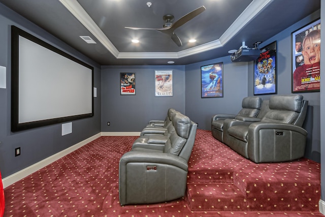 home theater with crown molding, a tray ceiling, and carpet floors