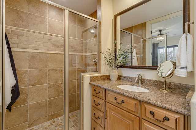 bathroom featuring vanity, an enclosed shower, and ceiling fan