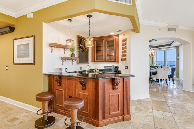 kitchen with a breakfast bar, decorative light fixtures, sink, kitchen peninsula, and crown molding