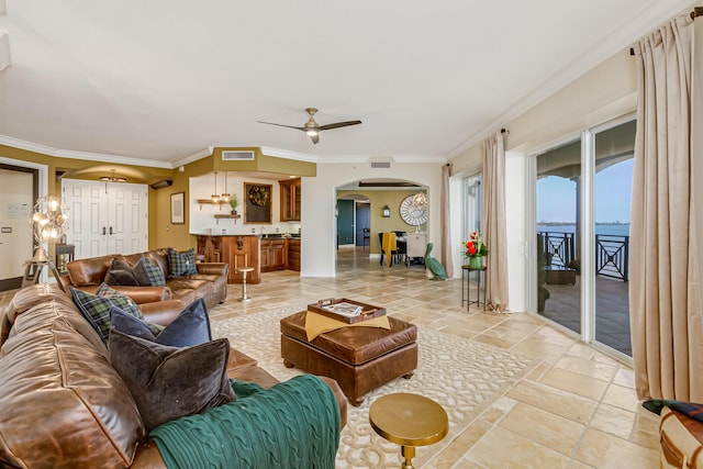 living room with ornamental molding, a water view, and ceiling fan