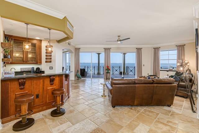 living room featuring ornamental molding, a water view, and ceiling fan