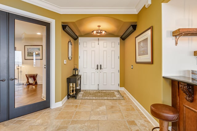 entryway featuring lofted ceiling, an inviting chandelier, a wall mounted AC, ornamental molding, and french doors