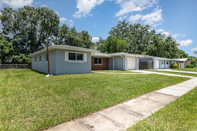 ranch-style house featuring a garage and a front lawn