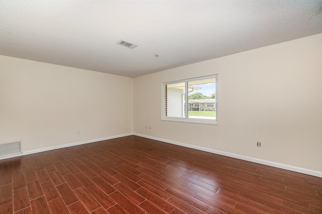 spare room with a textured ceiling and hardwood / wood-style floors