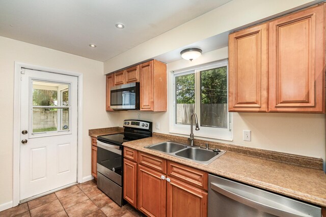 kitchen featuring appliances with stainless steel finishes, light tile patterned floors, and sink