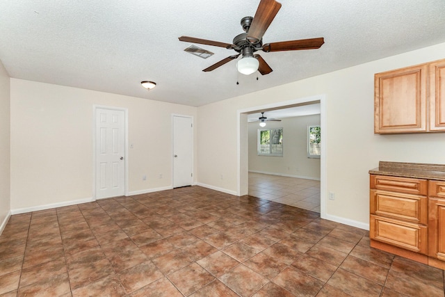 interior space with a textured ceiling and ceiling fan