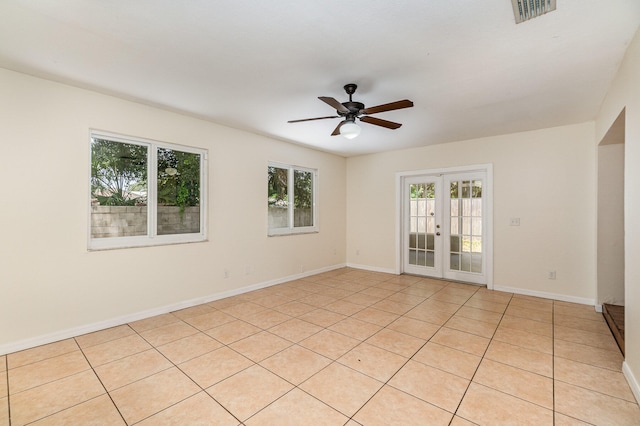 tiled spare room with ceiling fan and french doors