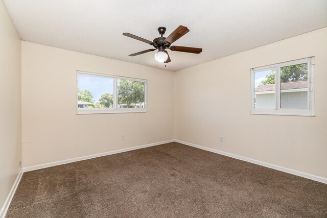 carpeted spare room featuring ceiling fan