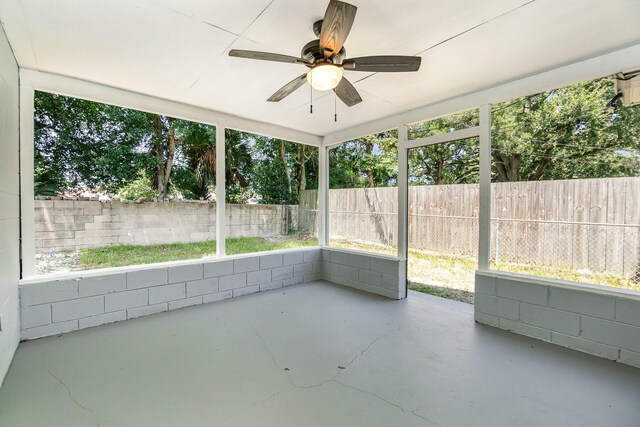 unfurnished sunroom featuring ceiling fan