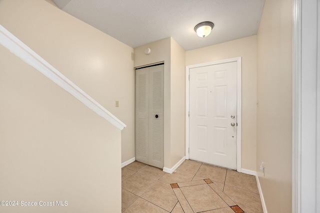 tiled foyer with a textured ceiling